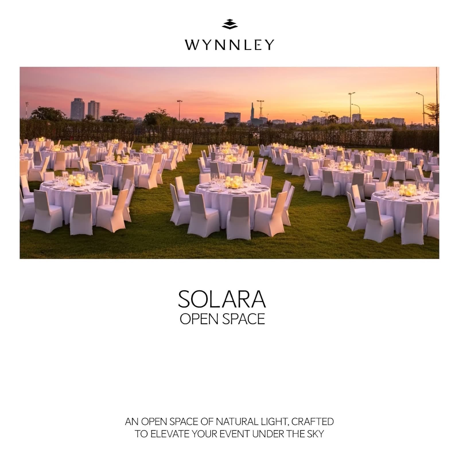 SOLARA open-air lawn at Wynnley set with candlelit round tables at sunset, city skyline in the background