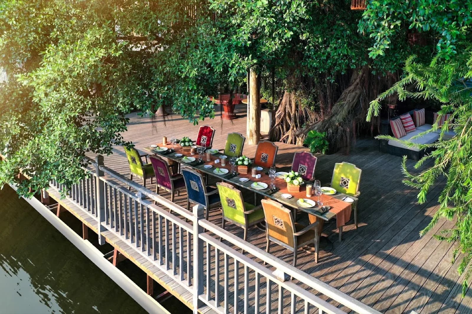 Colourful chairs arranged around a riverside banquet table