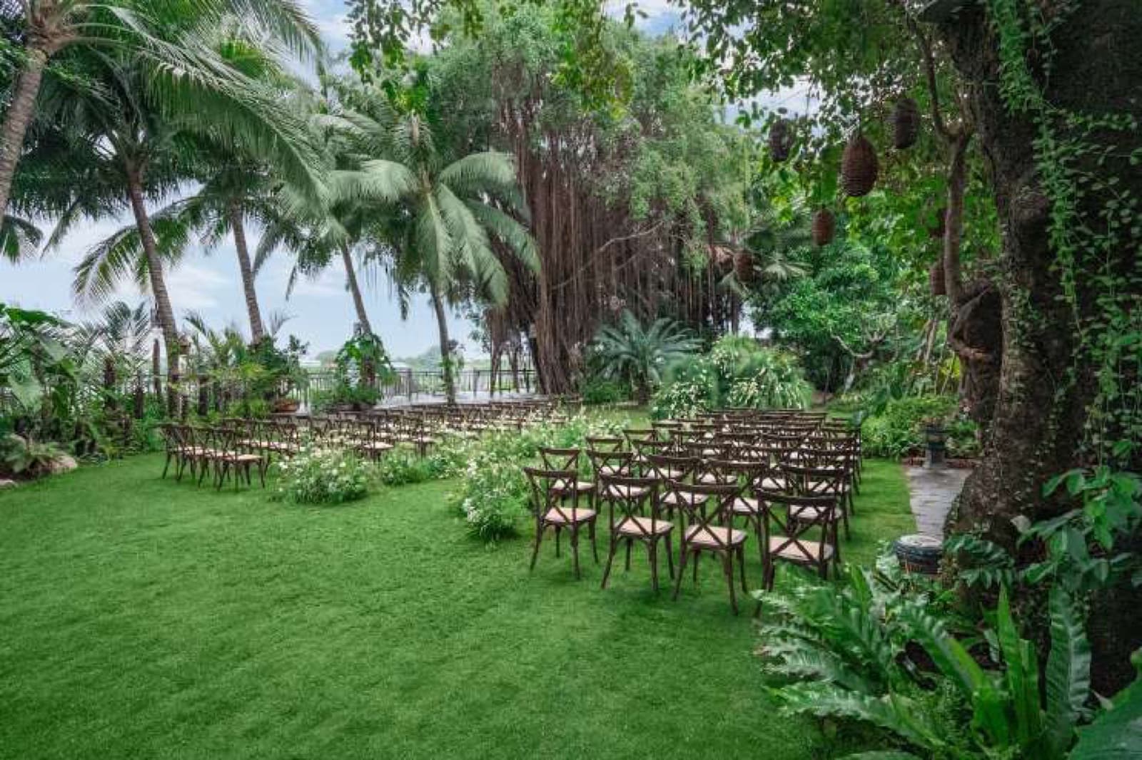 Garden ceremony seating arranged between palms and tropical planting