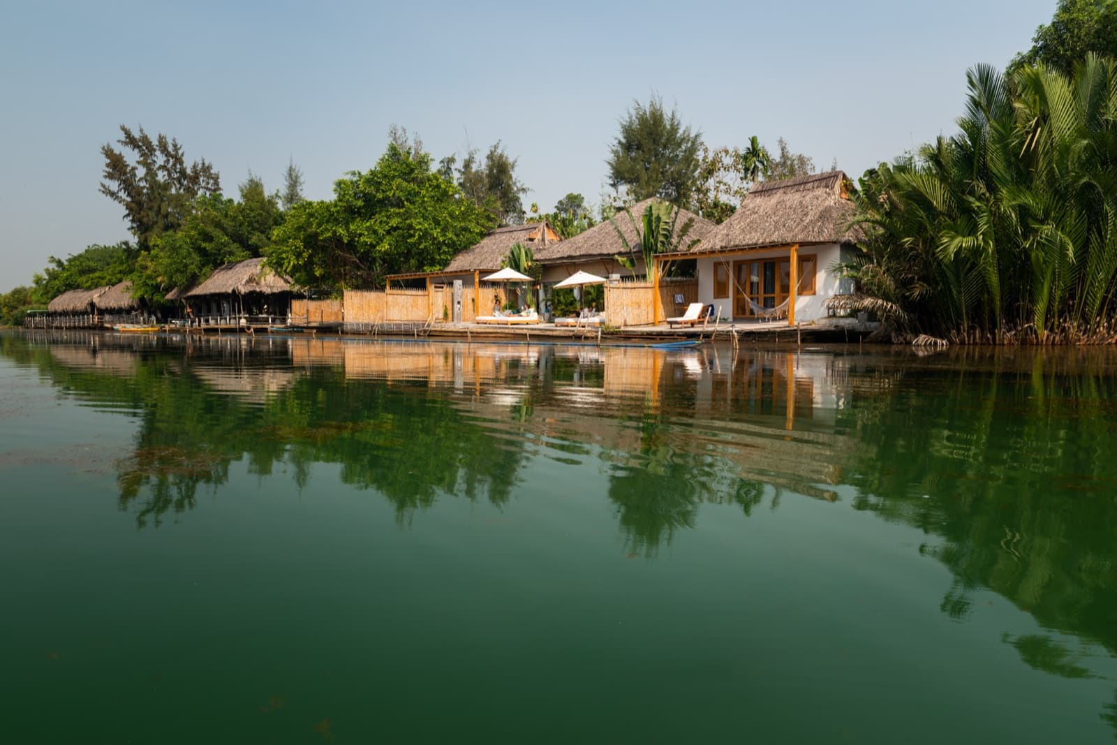 CHI-BU Riverside Resort cottages, riverfront lounge and gardens viewed across the Ông Kèo River