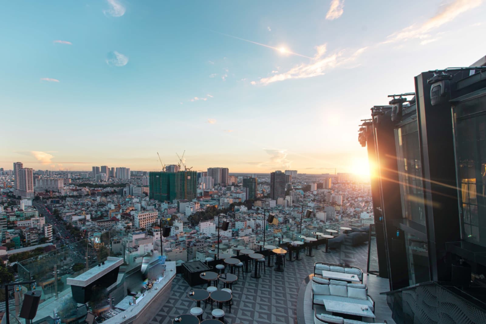 The outdoor Skybar Area at Chill Skybar, unoccupied at sunset, with its circular bar, lounge seating and panoramic Ho Chi Minh City view.