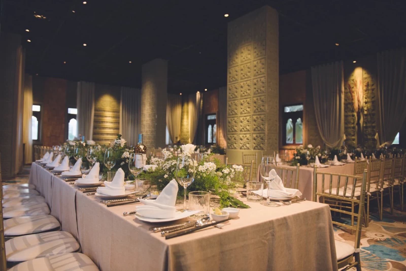 Riverside Art's carved stone pillars and feature statue beside long banquet tables set for a formal dinner