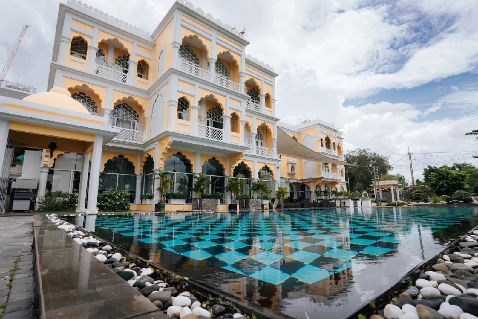 Daytime view of Sunset Garden's checkered infinity pool in front of the Chloe Gallery building, unoccupied