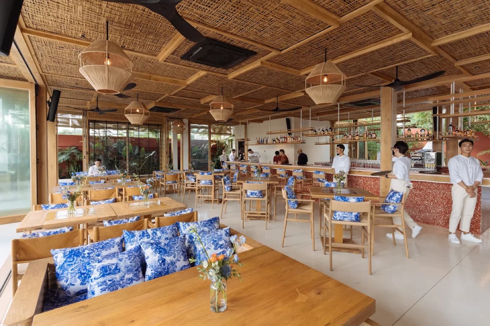 Clay Saigon's riverside indoor bar and dining area, empty, showing the marble bar counter and rattan seating.