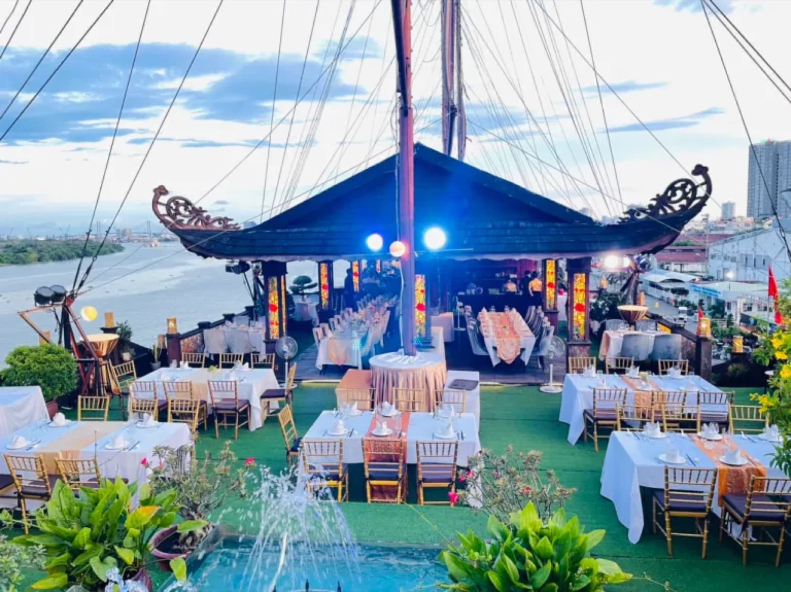 Back Deck arranged with banquet tables around the roofed pavilion and river-facing fountain