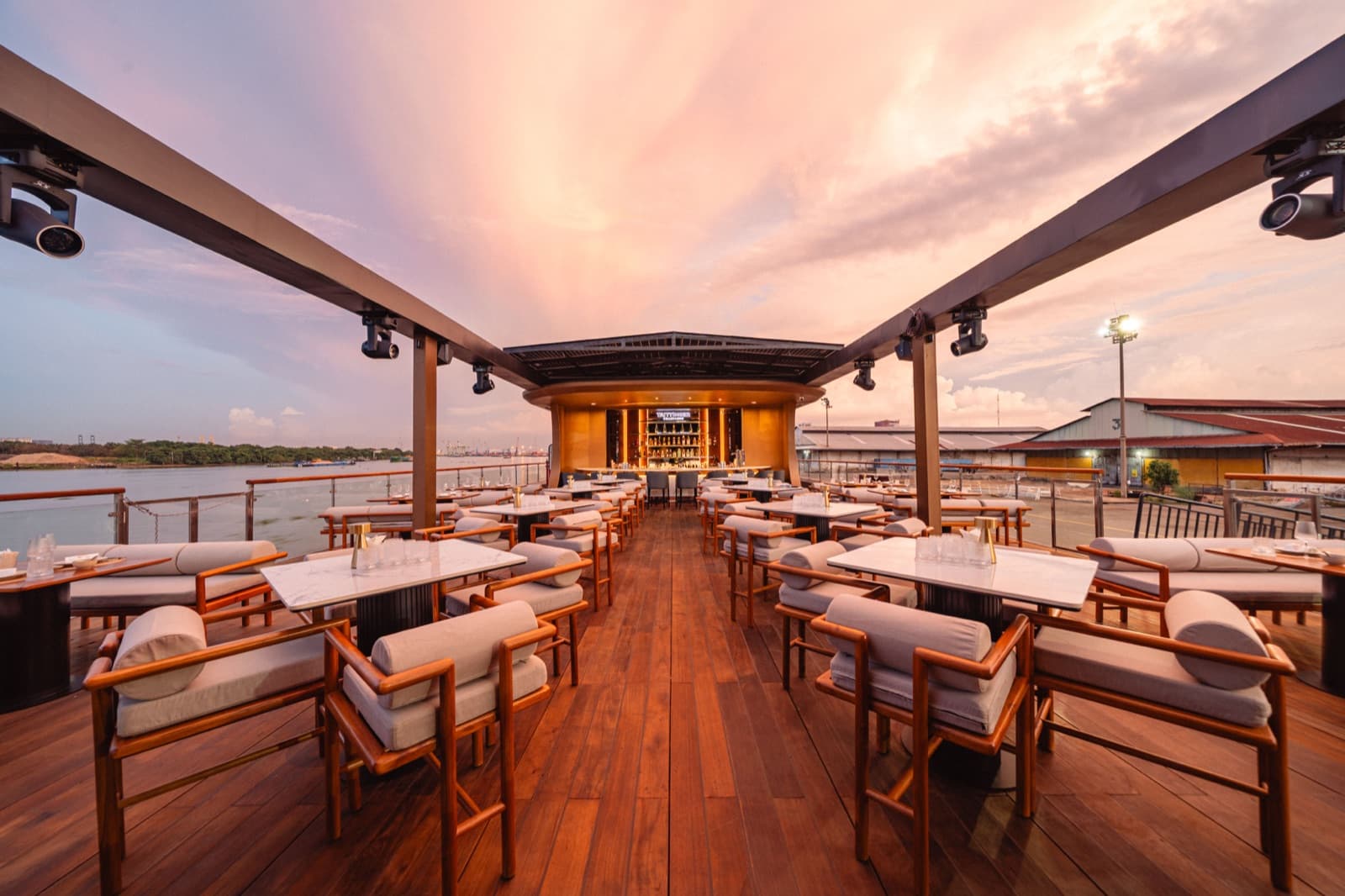 ICON Skydeck open-air rooftop deck at dusk aboard ICON Saigon, with lounge seating and a champagne bar