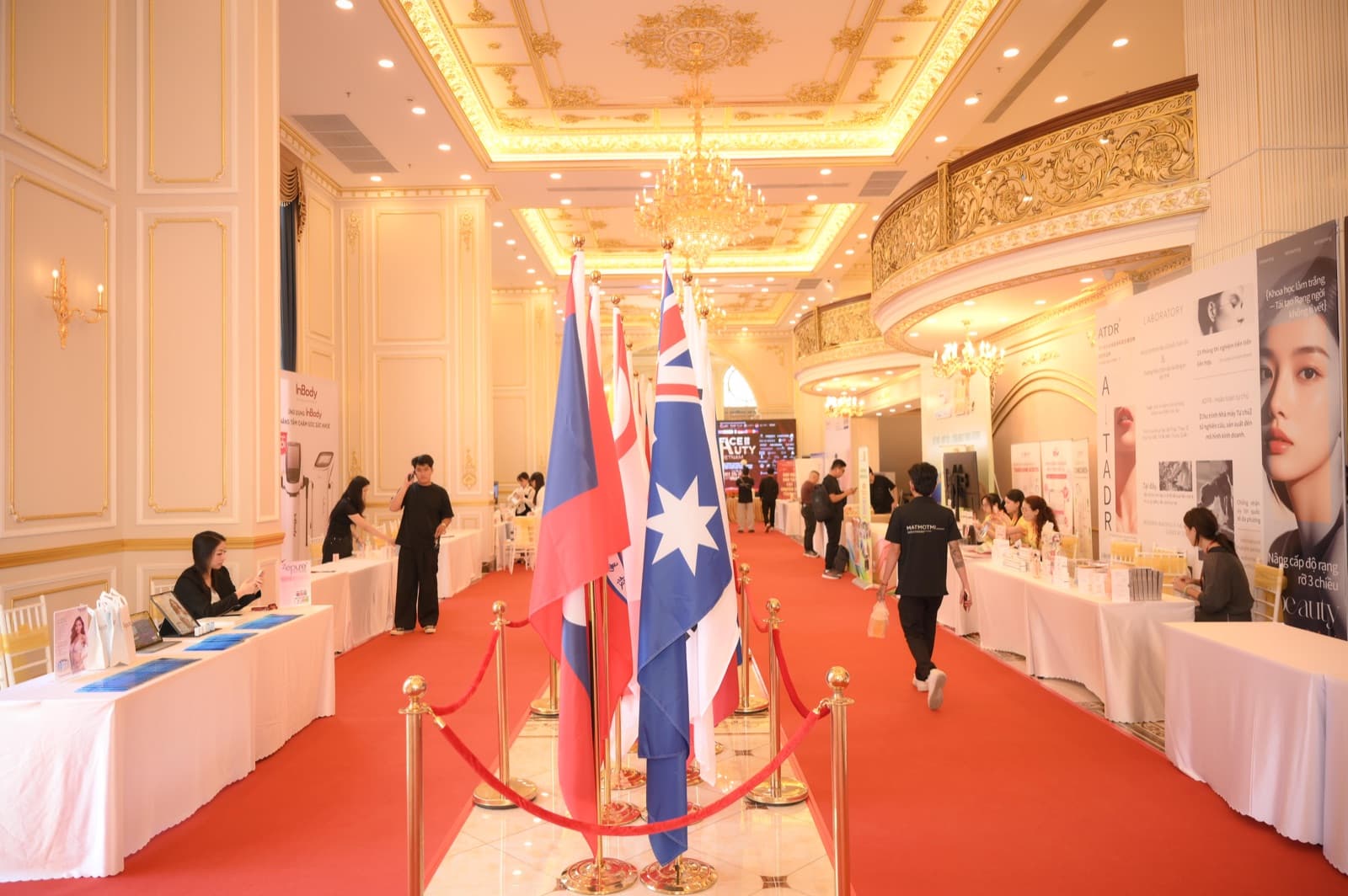 La Royal Hall set with a red carpet and flag stands for a formal reception, unoccupied.