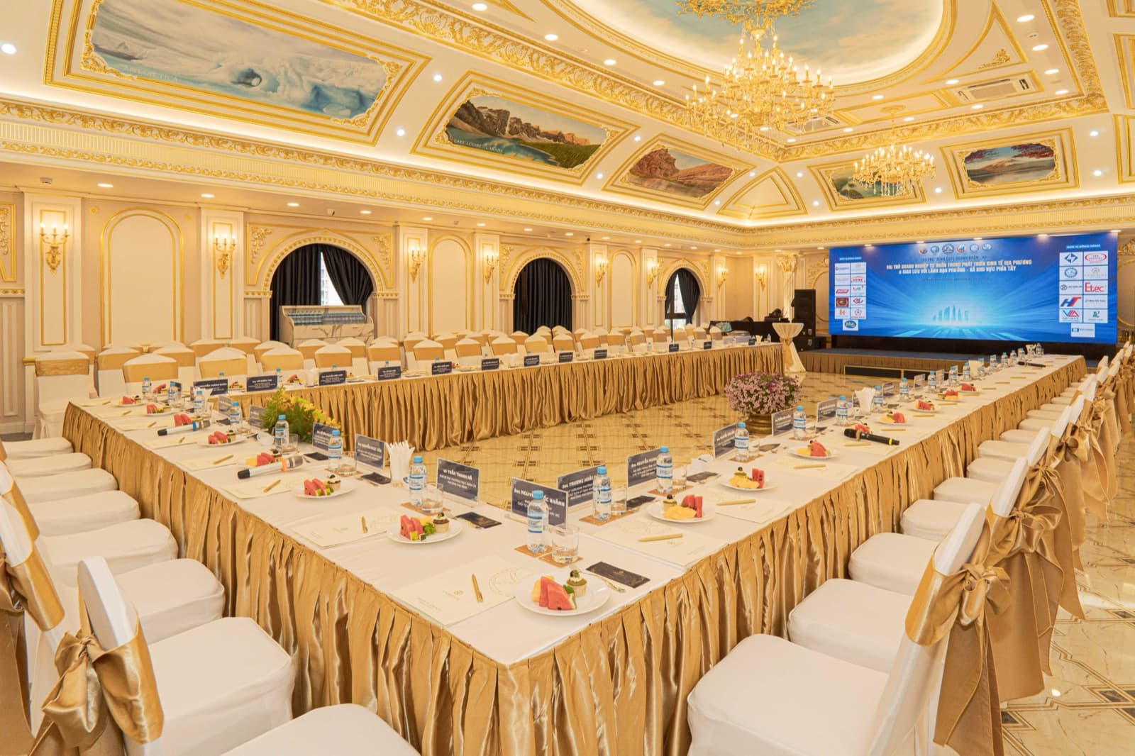 La Sky Ballroom in a U-shape conference layout facing a screen, unoccupied.