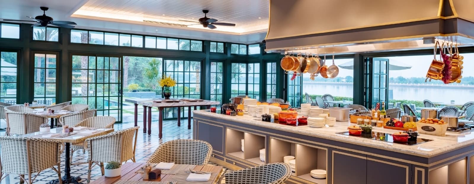 The dining room at Kitchen by the River, Mia Saigon, unoccupied, looking out to the river through full-height windows.