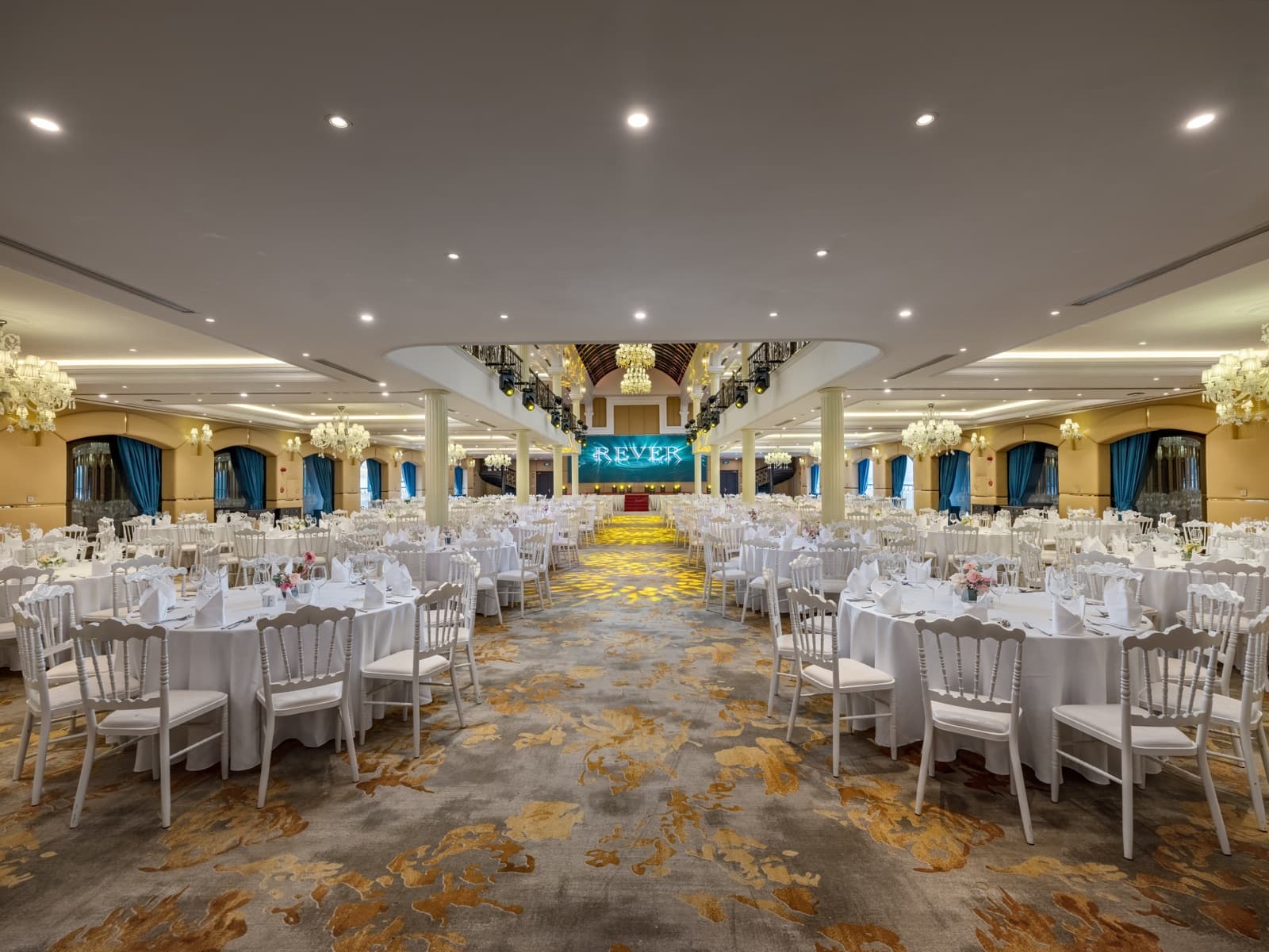 REVER Hall empty of guests with round banquet tables and central aisle