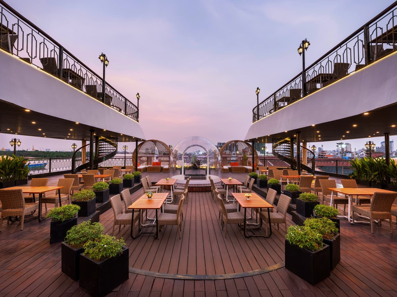 Open lounge-bar deck with paired seating terraces at dusk
