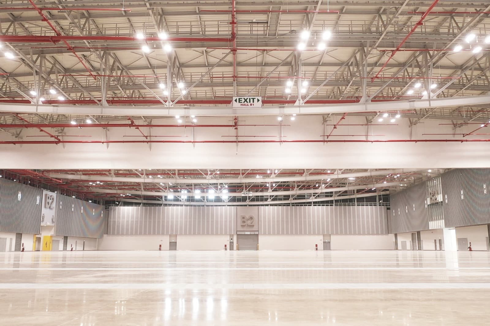 Empty SECC Exhibition Hall B beneath exposed red roof services