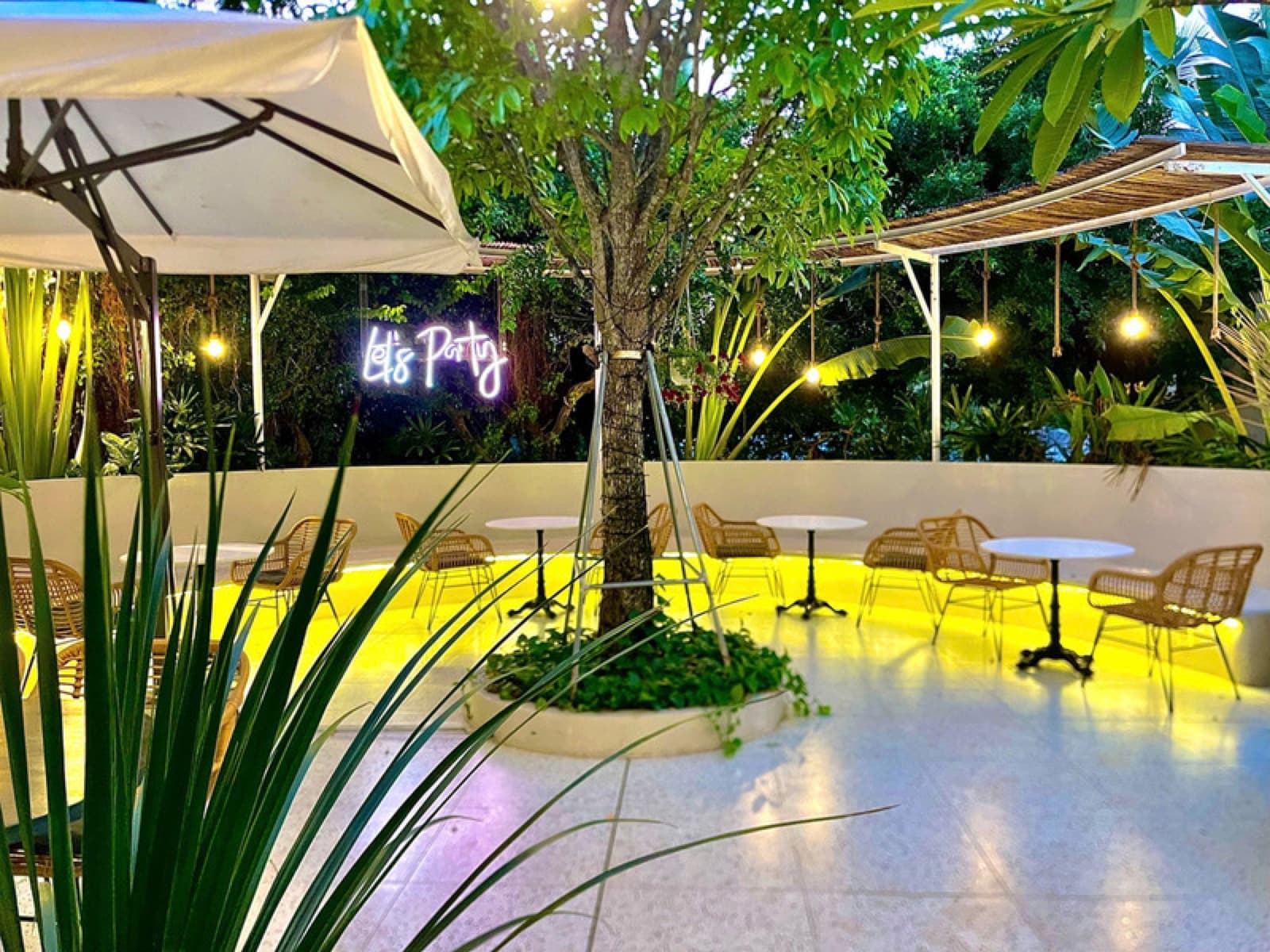 Coral B outdoor lounge with illuminated party signage and cocktail tables