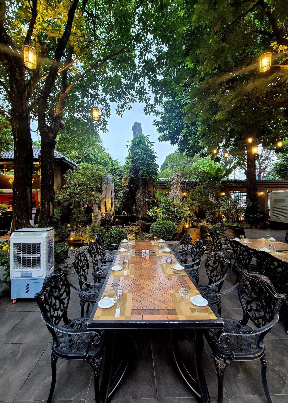 Outdoor table set for dining beside a rockery water feature