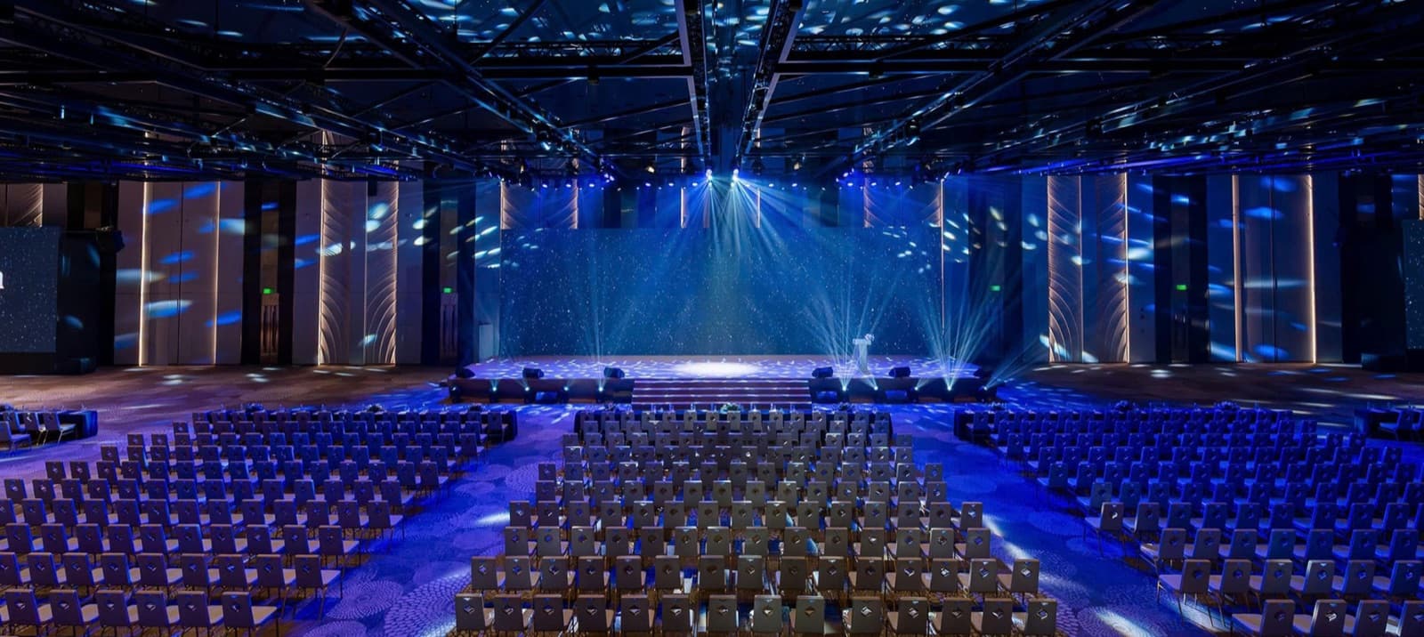 Grand Skylar set theatre-style with rows of empty chairs facing a stage under blue lighting