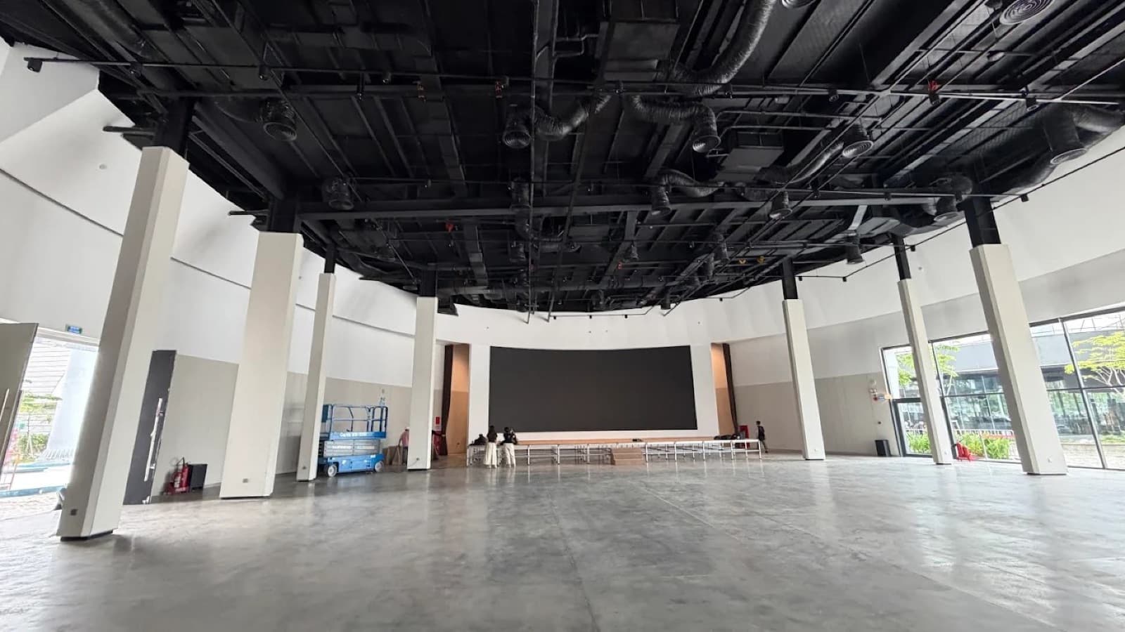 Symphony Hall at Thủ Thiêm Riverstage, unoccupied, looking toward the screen wall beneath the exposed technical ceiling.