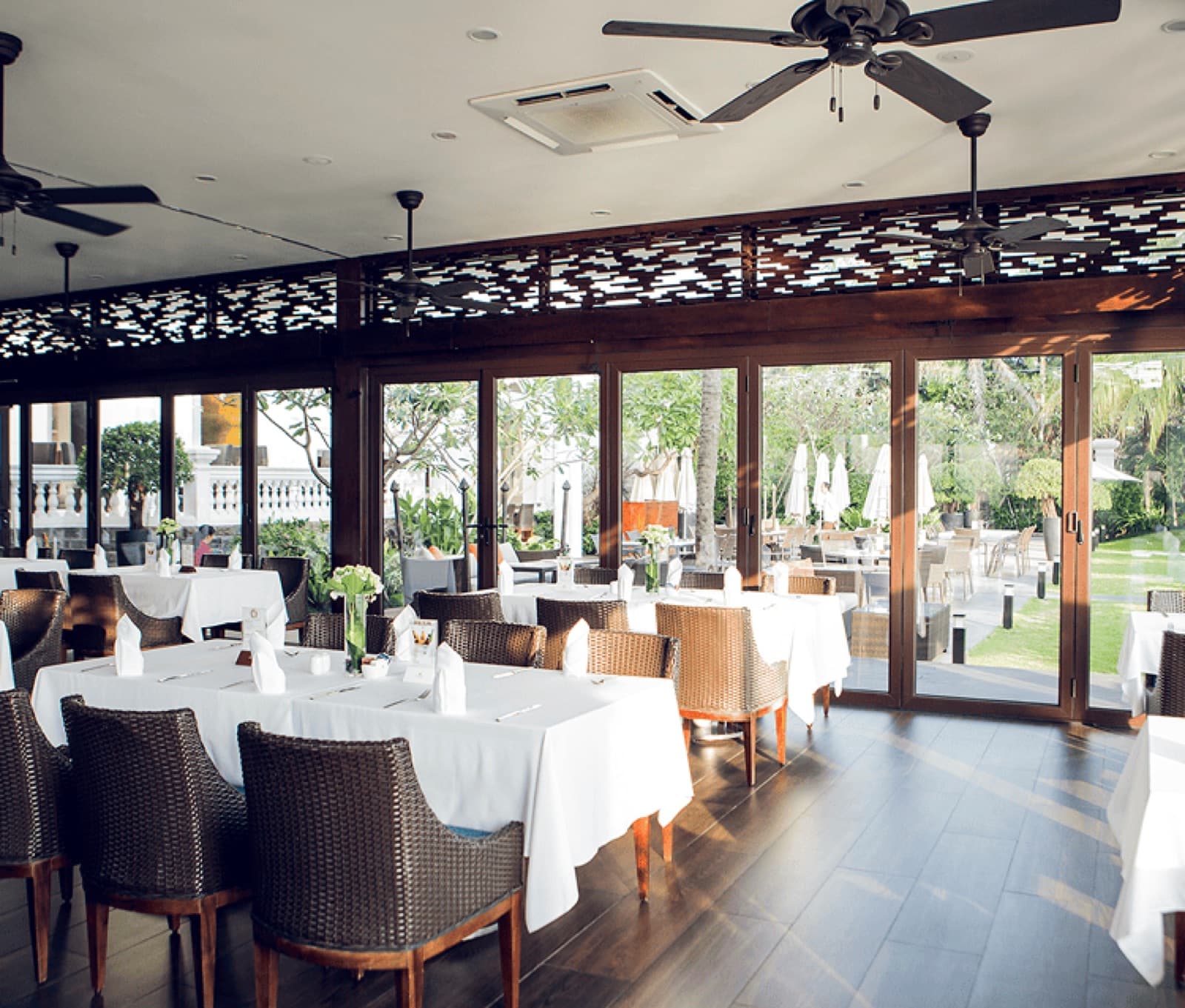 The Dining Hall at Villa Sông Saigon set for an event, its arched windows looking onto the garden.