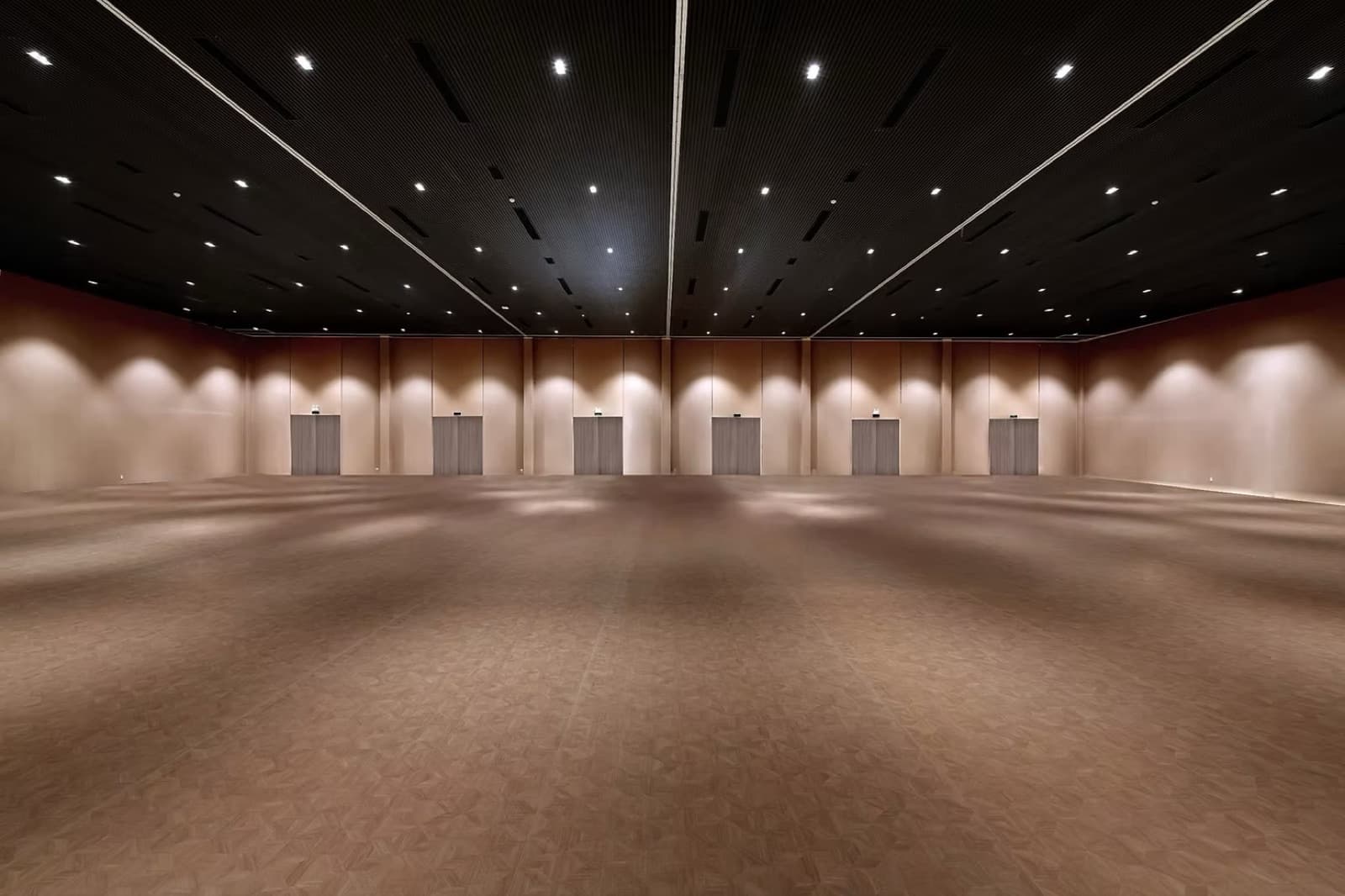 Empty view of TERRA Grand Ballroom at Wynnley, showing the full hall with dark ceiling and perimeter doors